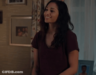 A Woman Is Clapping Her Hands In A Living Room In Front Of A Window . GIF