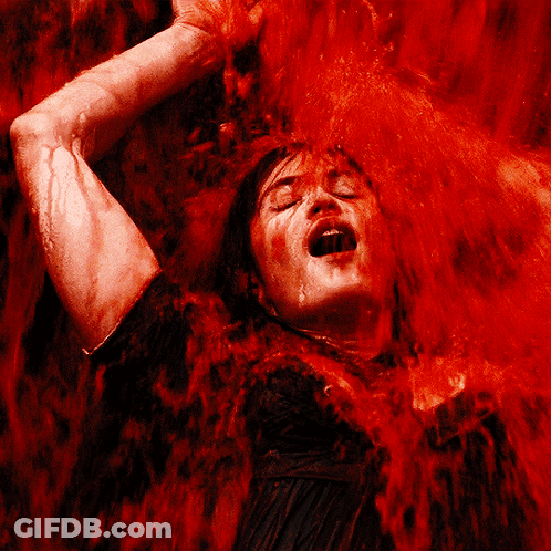A Woman Is Covered In Red Liquid With Her Mouth Wide Open GIF