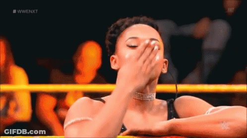 A Woman Is Covering Her Face In A Wrestling Ring . GIF