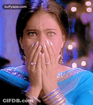 A Woman Is Covering Her Face With Her Hands And A Ring . GIF