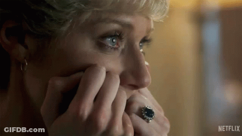 A Woman Is Covering Her Face With Her Hands And Wearing A Ring On Her Finger . GIF