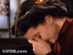 A Woman Is Covering Her Face With Her Hands In A Close Up Of Her Face . GIF