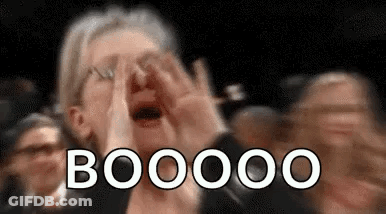 A Woman Is Covering Her Face With Her Hands While A Crowd Of People Applaud . GIF