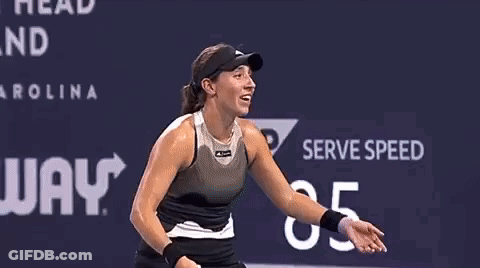 A Woman Is Covering Her Face With Her Hands While Playing Tennis On A Court . GIF