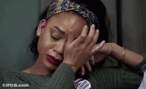 A Woman Is Covering Her Face With Her Hands While Wearing A Headband . GIF