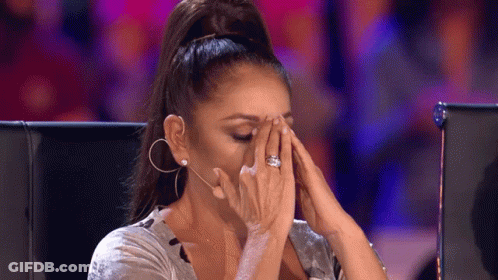 A Woman Is Covering Her Face With Her Hands While Wearing A Ring . GIF