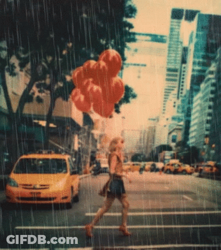 A Woman Is Crossing A Street In The Rain With Balloons In Her Hand GIF