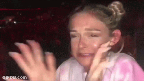 A Woman Is Crying And Covering Her Face With Her Hands While Sitting In A Car . GIF