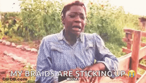 A Woman Is Crying And Saying `` My Braids Are Sticking Up '' While Sitting In Front Of A Wooden Fence . GIF