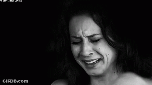 A Woman Is Crying In A Black And White Photo While Covering Her Face With Her Hand . GIF