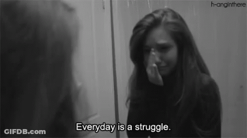 A Woman Is Crying In Front Of A Mirror With The Words " Everyday Is A Struggle " GIF