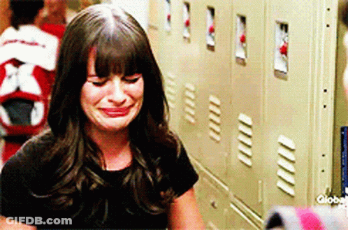 A Woman Is Crying In Front Of A Row Of Lockers GIF
