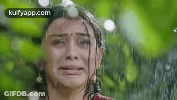 A Woman Is Crying In The Rain And Making A Funny Face . GIF