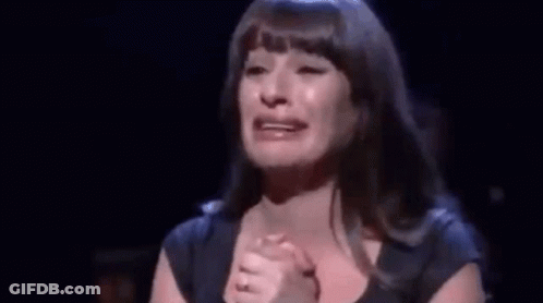 A Woman Is Crying On Stage While Holding Her Hands To Her Chest . GIF