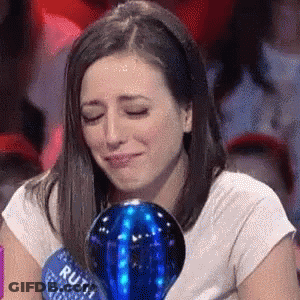 A Woman Is Crying While Holding A Blue Ball That Says Ruth On It GIF