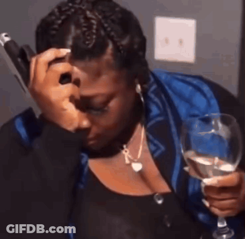 A Woman Is Crying While Holding A Glass Of Wine And Talking On A Cell Phone . GIF
