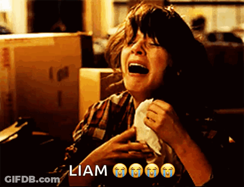 A Woman Is Crying While Holding A Napkin In Front Of A Box That Says ' Liam ' On It GIF