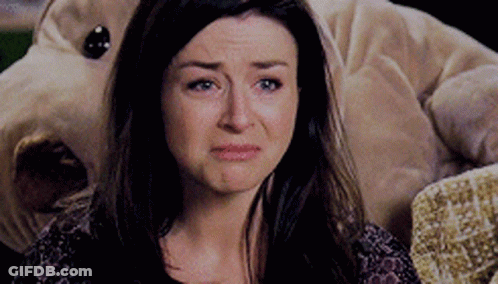 A Woman Is Crying While Sitting In Front Of A Stuffed Dog . GIF