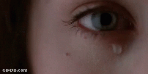 A Woman Is Crying With A Tear Coming Out Of Her Eye . GIF