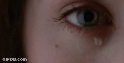 A Woman Is Crying With A Tear Coming Out Of Her Eye . GIF