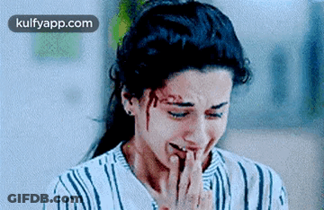 A Woman Is Crying With Blood On Her Face And Covering Her Mouth With Her Hand . GIF