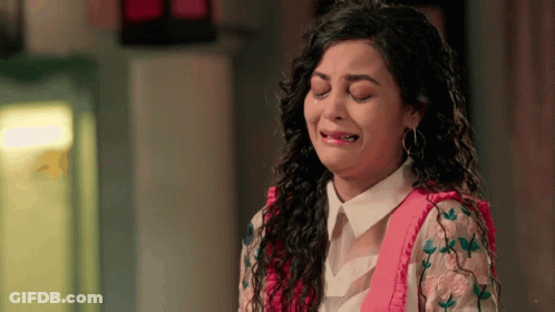 A Woman Is Crying With Her Eyes Closed And A Pink Shirt On GIF