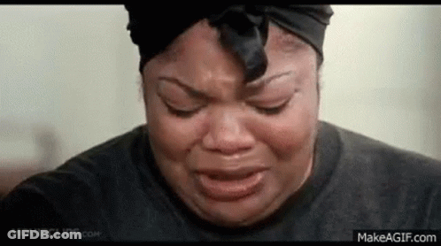 A Woman Is Crying With Her Eyes Closed And Wearing A Black Headband . GIF