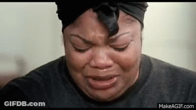 A Woman Is Crying With Her Eyes Closed And Wearing A Black Headband . GIF