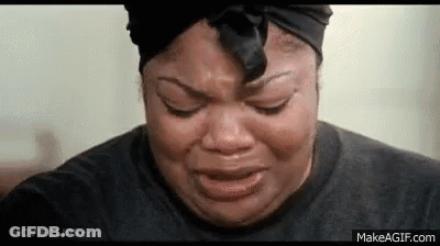 A Woman Is Crying With Her Eyes Closed And Wearing A Black Headband . GIF