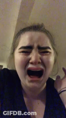 A Woman Is Crying With Her Mouth Open And Making A Funny Face . GIF