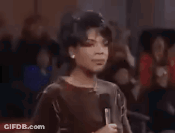A Woman Is Dancing In A Club With Her Hands In The Air And Her Mouth Open . GIF