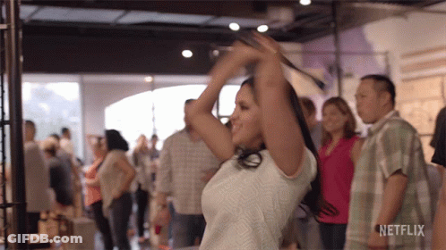 A Woman Is Dancing In A Crowd With A Netflix Logo On The Bottom Right GIF