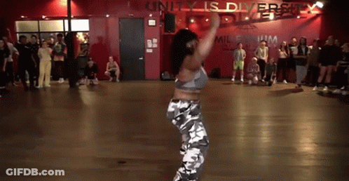 A Woman Is Dancing In A Dance Studio In Front Of A Crowd . GIF