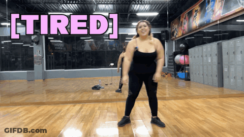 A Woman Is Dancing In A Gym With The Words Tired Above Her GIF