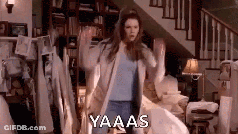 A Woman Is Dancing In A Living Room In Front Of A Staircase In A House . GIF