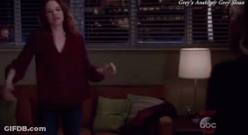 A Woman Is Dancing In A Living Room With The Words Grey 'S Anatomy Grey Sloan Written Above Her GIF