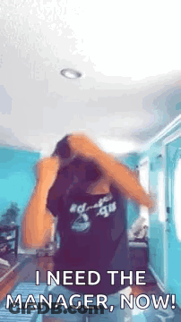 A Woman Is Dancing In A Room And Saying `` I Need The Manager , Now '' . GIF