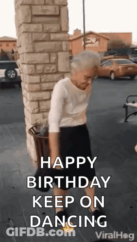 A Woman Is Dancing In Front Of A Brick Wall . GIF