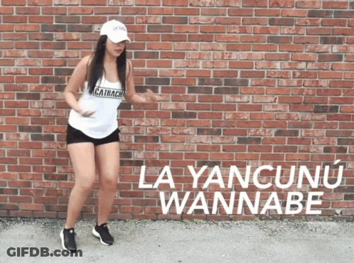 A Woman Is Dancing In Front Of A Brick Wall That Says La Yancunun Wannabe GIF
