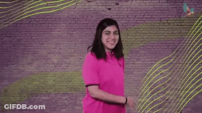 A Woman Is Dancing In Front Of A Brick Wall With The Words `` We Got This '' Written On It . GIF