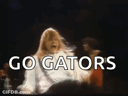 A Woman Is Dancing In Front Of A Crowd And The Words Go Gators Are Visible GIF