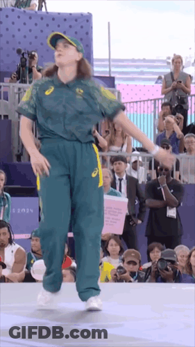 A Woman Is Dancing In Front Of A Crowd With A Sign That Says 2024 On It GIF