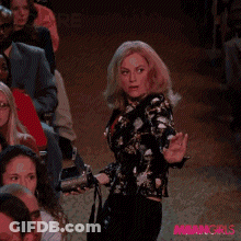 A Woman Is Dancing In Front Of A Crowd With The Words " You 'Re Doing " Behind Her GIF
