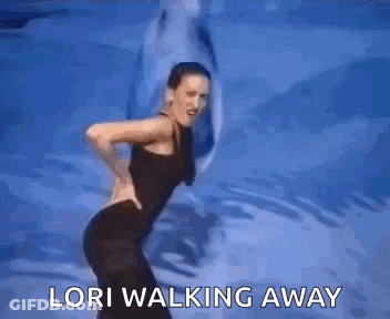 A Woman Is Dancing In Front Of A Dolphin And The Words `` Lori Walking Away '' . GIF