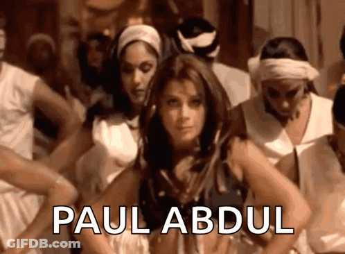 A Woman Is Dancing In Front Of A Group Of People And The Name Paul Abdul Is On The Bottom GIF