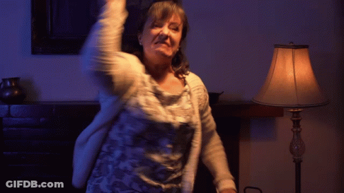 A Woman Is Dancing In Front Of A Lamp In A Room GIF