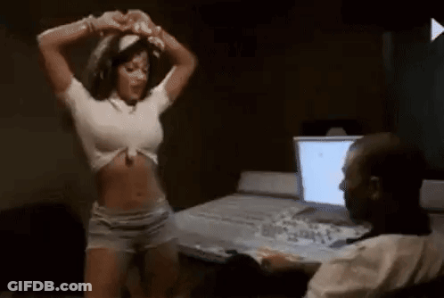 A Woman Is Dancing In Front Of A Man Sitting At A Desk . GIF
