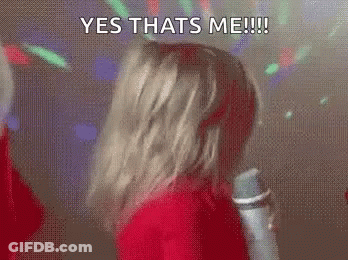 A Woman Is Dancing In Front Of A Microphone With The Words `` Yes Thats Me '' Written On Her Face . GIF