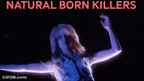 A Woman Is Dancing In Front Of A Sign That Says Natural Born Killerss GIF