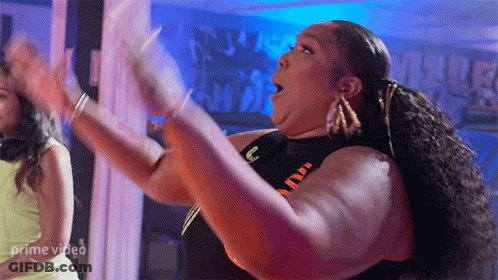 A Woman Is Dancing In Front Of A Sign That Says Prime Video On It GIF